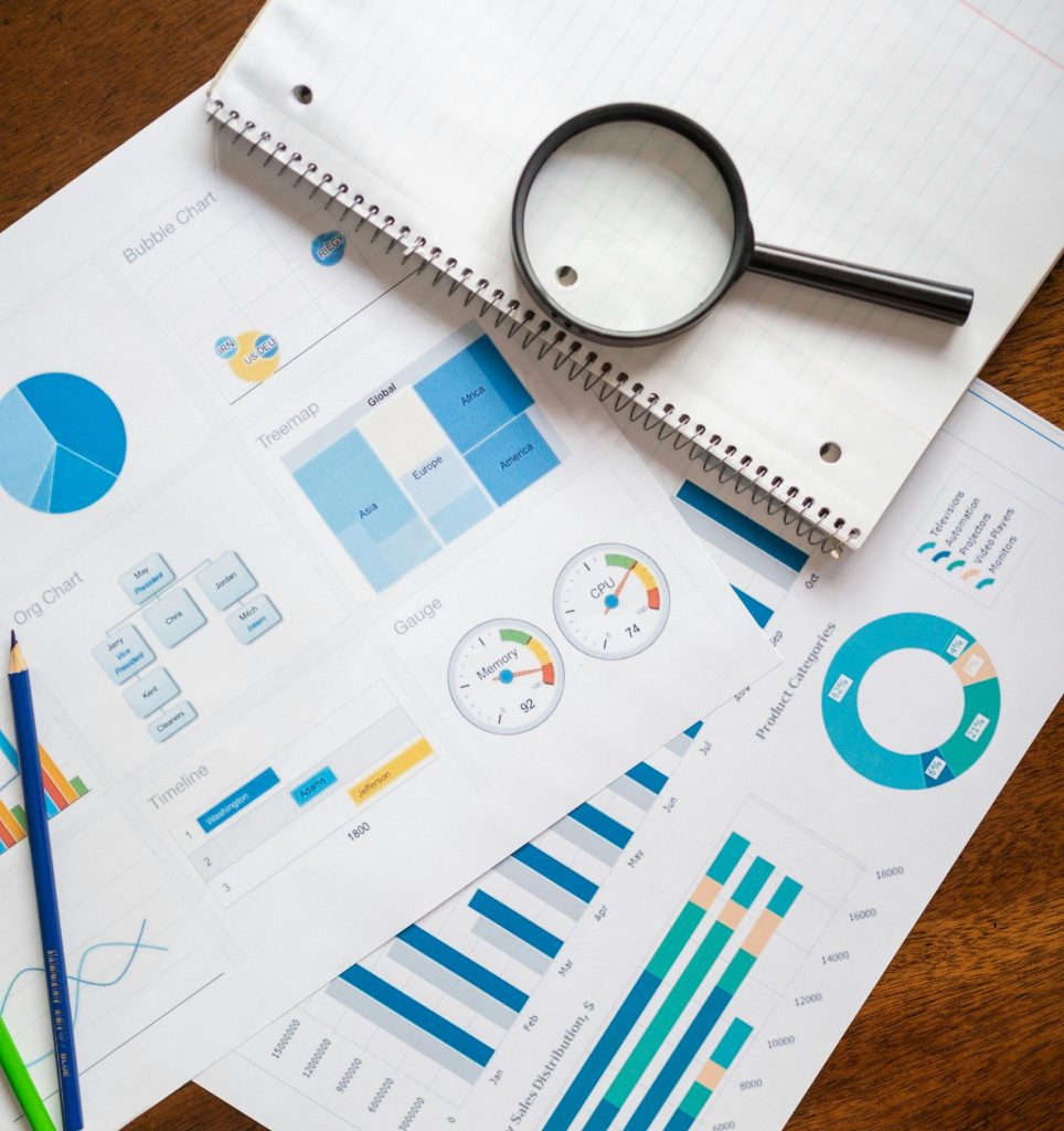 Lupa y cuaderno junto a gráficos de rendimiento que ilustran el análisis y optimización del crawl budget en un sitio web.