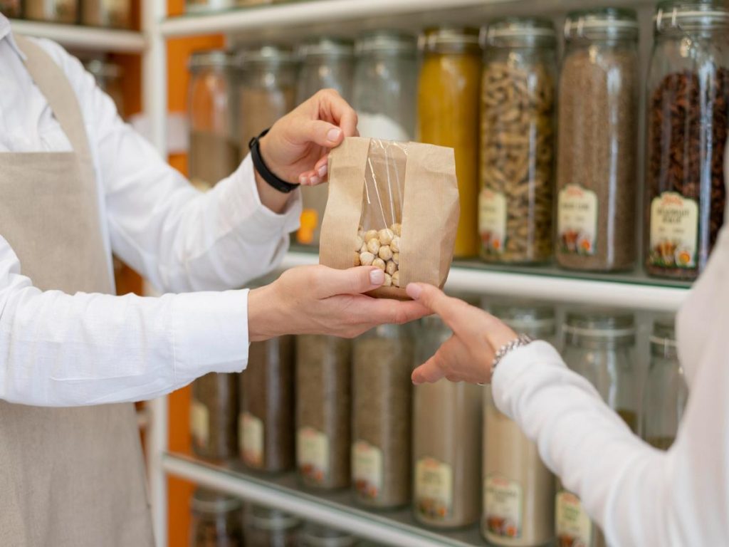 Imagen que muestra a un cliente recibiendo un paquete con frutos secos en una tienda especializada, destacando la importancia de un buen diseño web para empresa de alimentación en Barcelona.